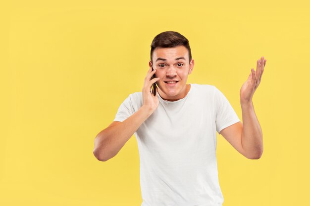 Portrait demi-longueur du jeune homme caucasien sur mur jaune