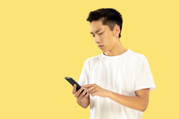 Portrait demi-longueur du jeune homme coréen sur jaune