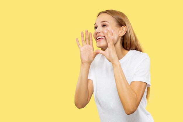 Portrait de demi-longueur de jeune femme caucasienne sur studio jaune