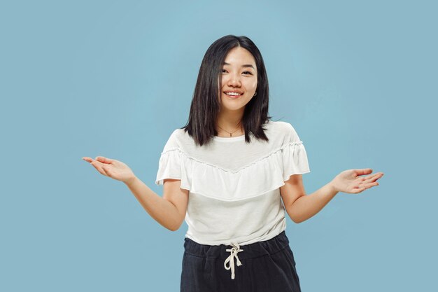 Portrait demi-longueur de la jeune femme coréenne sur bleu