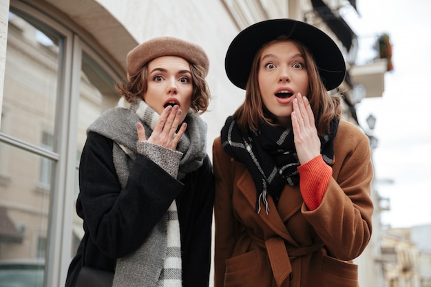 Portrait de deux filles surprises habillées en vêtements d'automne