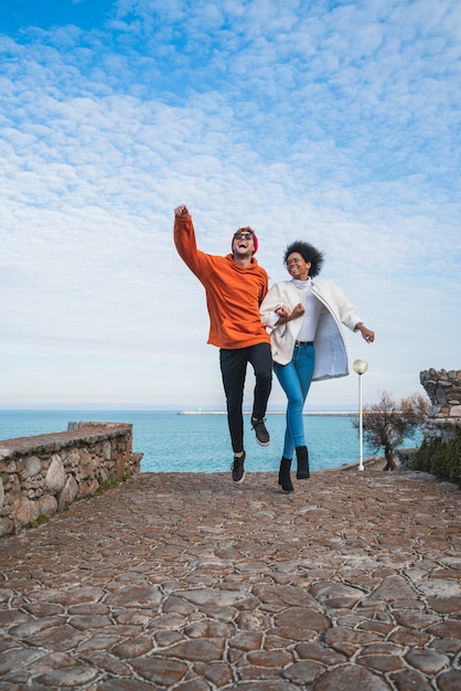 Portrait de deux jeunes amis passant du bon temps ensemble, marchant sur la côte et s'amusant.