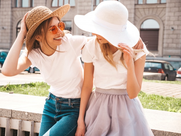 Portrait De Deux Jeunes Belles Filles Blondes Souriantes Hipster Dans Des Vêtements De T-shirt Blanc à La Mode D'été.