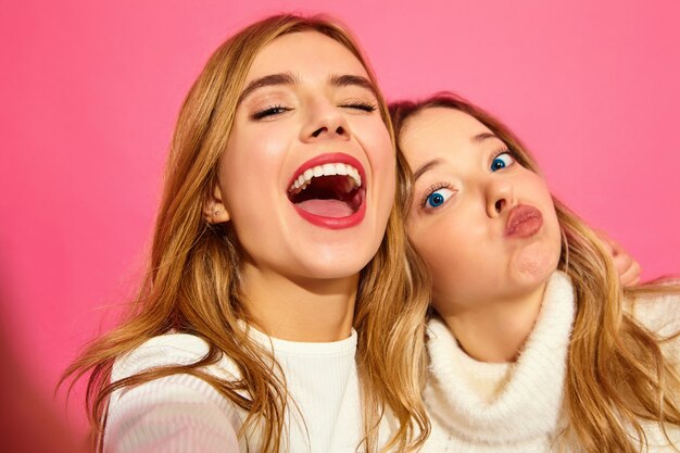 Portrait de deux jeunes femmes blondes souriantes élégantes