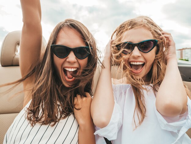 Portrait de deux jeunes femmes hipster belle et souriante en voiture décapotable