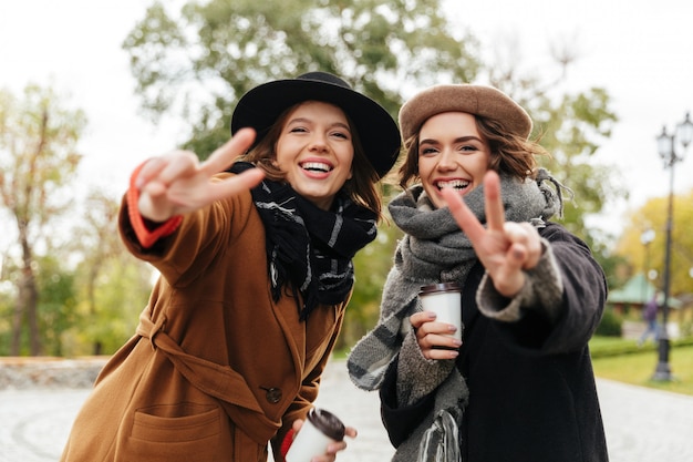 Portrait de deux jeunes filles souriantes vêtues de manteaux