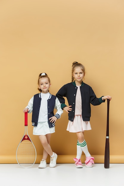 Portrait de deux jeunes filles en tant que joueurs de tennis tenant une raquette de tennis.