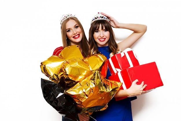 Portrait de deux jolies femmes avec des ballons lumineux et des coffrets cadeaux