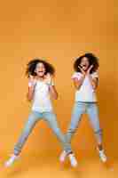 Photo gratuite portrait de deux sœurs afro-américaines sautant