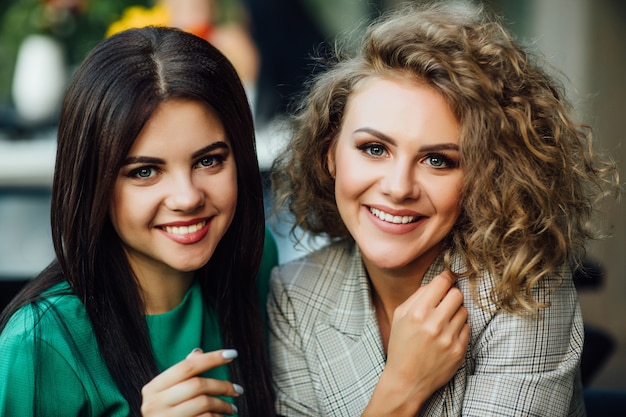 Portrait de deux soeurs jeunes et mignonnes souriantes, passé le week-end drôle dans la convivialité du café.