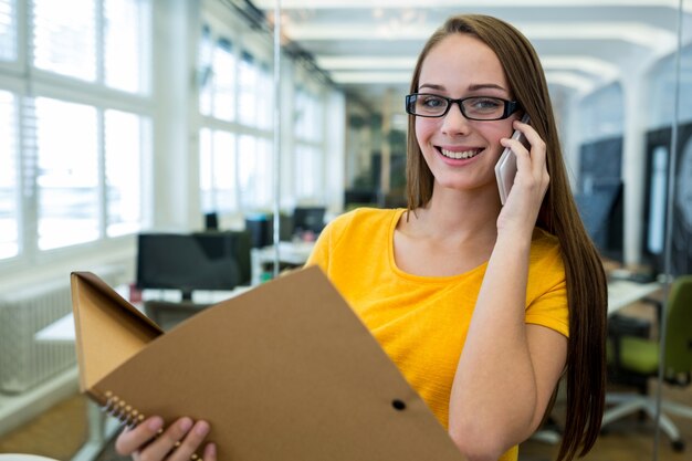 Portrait de dirigeant d&#39;entreprise femme tenant un fichier et de parler sur téléphone mobile