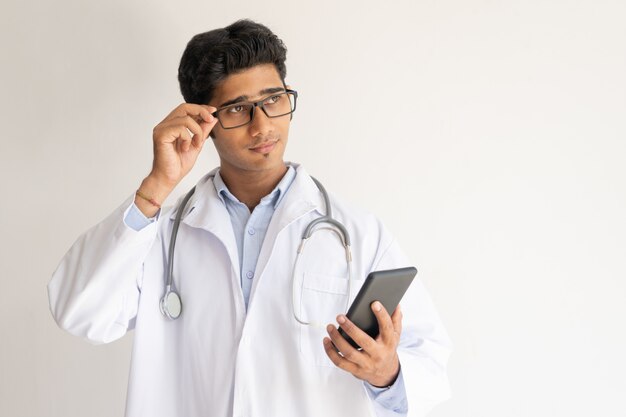 Portrait d&#39;un docteur pensif avec smartphone