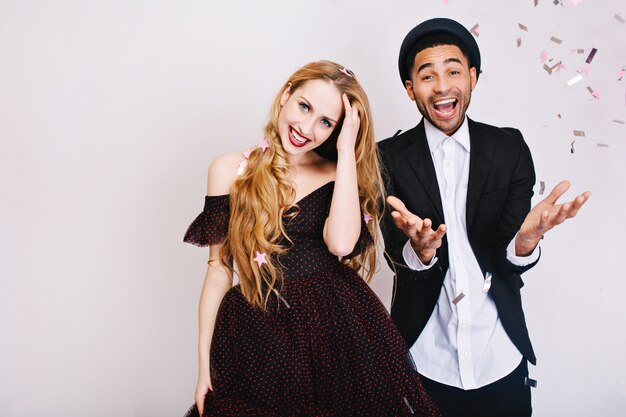 Portrait drôle de célébration de couple joyeux amoureux dans des vêtements de soirée de luxe s'amuser ensemble. fête, bonheur, souriant, exprimant de vraies émotions positives.