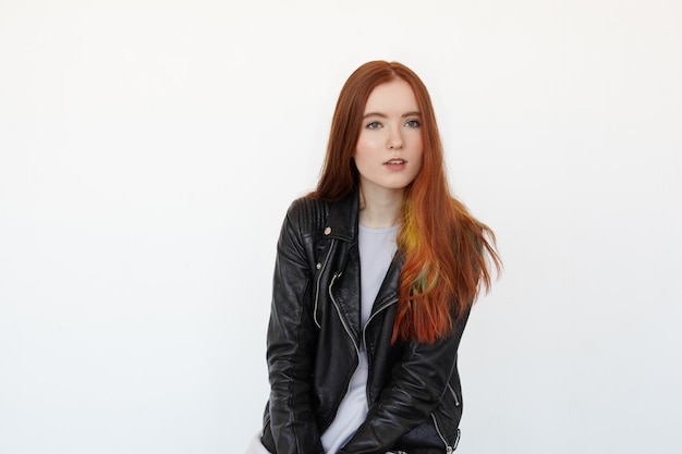 Portrait du beau modèle féminin aux longs cheveux roux et aux yeux verts en veste de cuir noir