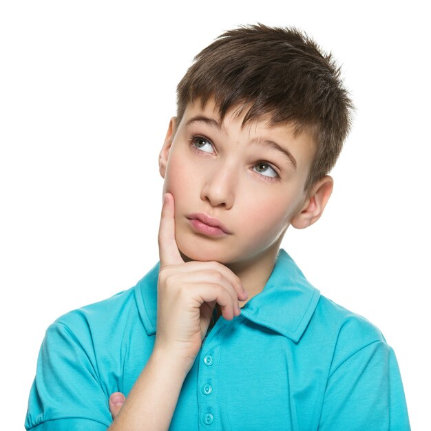 Portrait du jeune garçon adolescent pensant souriant lève les yeux dans les occasionnels - isolé sur blanc.