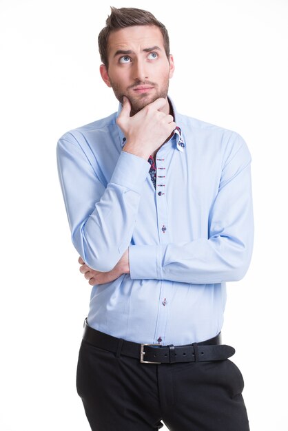 Portrait du jeune homme pensant lève les yeux dans les occasionnels isolés