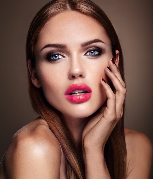 Portrait du modèle de la belle fille avec le maquillage de soirée et la coiffure romantique. lèvres rouges