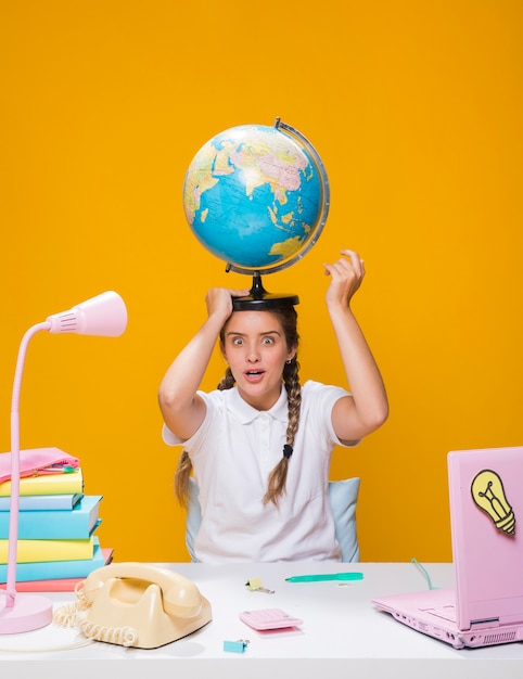 Photo gratuite portrait d'écolière avec un globe