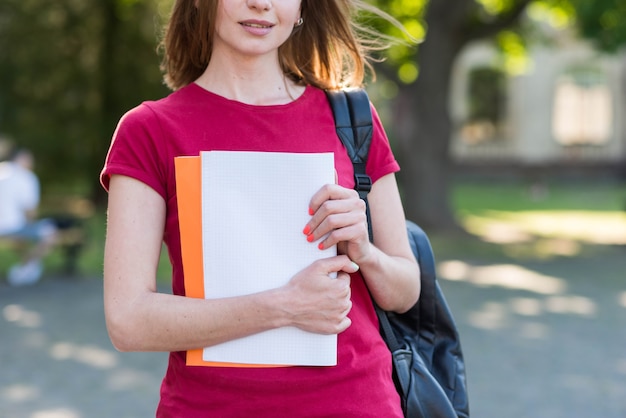 Photo gratuite portrait d'écolière avec des livres dans le parc