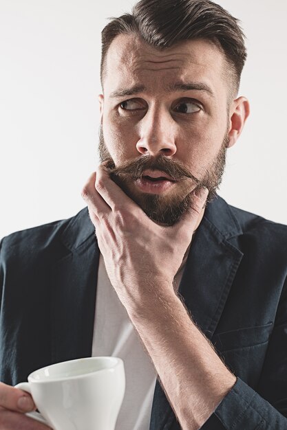 Portrait de l'élégant beau jeune homme avec une tasse de café