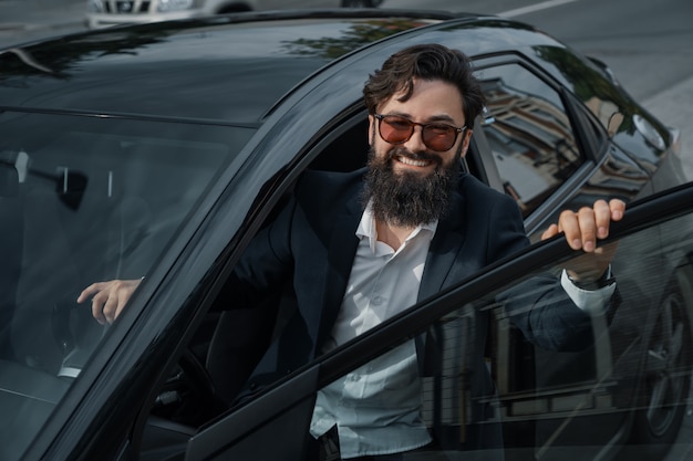 Portrait élégant, bel homme près de voiture à l'extérieur