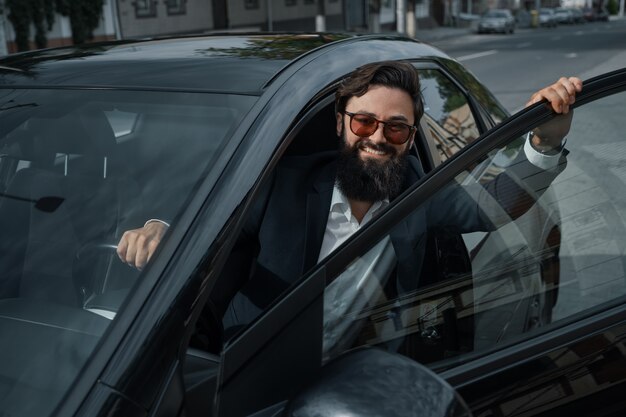 Portrait élégant, bel homme près de voiture à l'extérieur