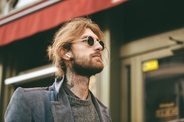 Portrait d'un élégant homme barbu dans les écouteurs