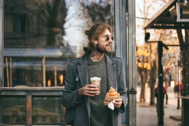 Portrait d'un élégant homme barbu habillé en manteau