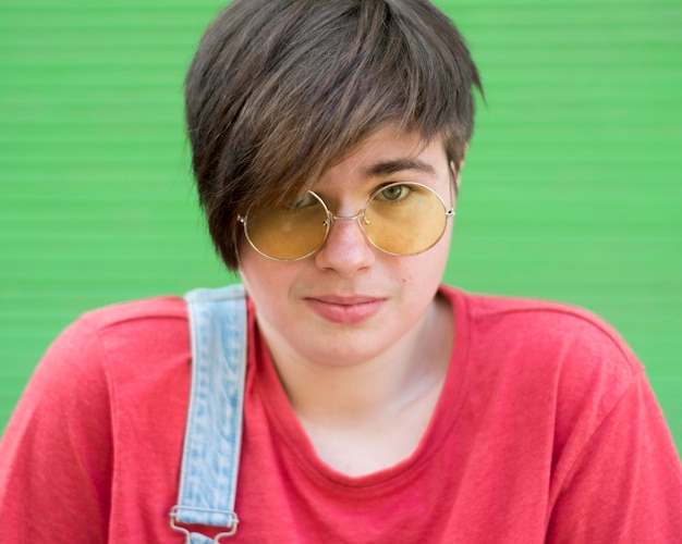 Photo gratuite portrait d'élégant jeune garçon portant des lunettes de soleil