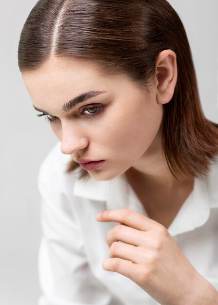 Portrait d'élégant modèle féminin posant en chemise blanche. nouveau concept de féminité