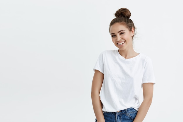 Portrait d'élégante femme européenne moderne avec une coiffure chignon souriant largement