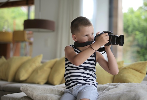 Photo gratuite portrait d'un enfant à la maison avec appareil photo numérique