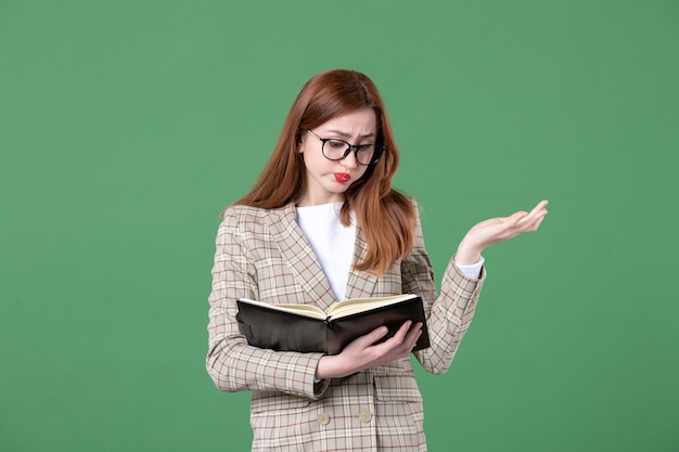 Portrait d'enseignante écrivant des notes sur le vert