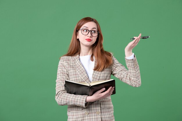 Portrait d'enseignante écrivant des notes sur le vert