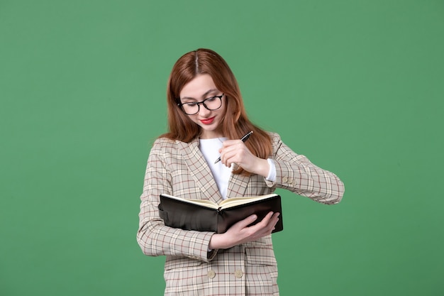 Portrait d'enseignante écrivant des notes sur le vert