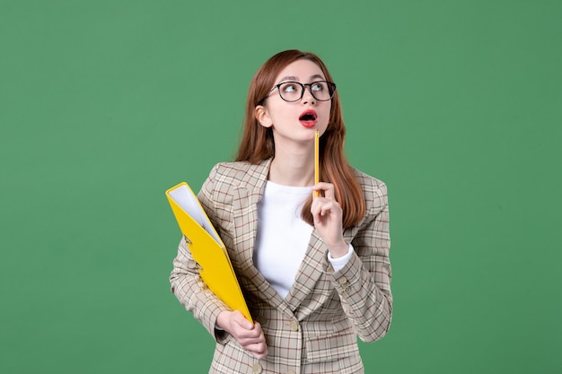 Portrait d'enseignante avec des fichiers jaunes sur vert