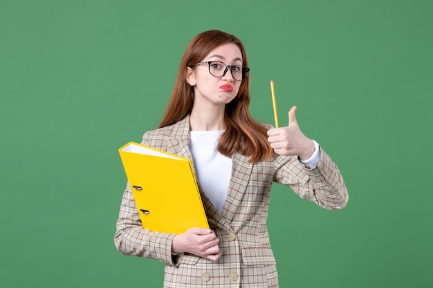 Portrait d'enseignante avec des fichiers jaunes sur vert