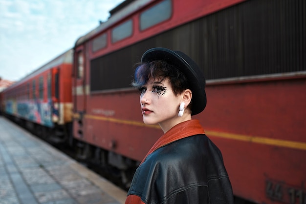 Portrait esthétique pop punk d'une femme posant devant une locomotive