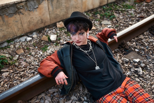 Portrait esthétique pop punk d'une femme posant sur des voies ferrées