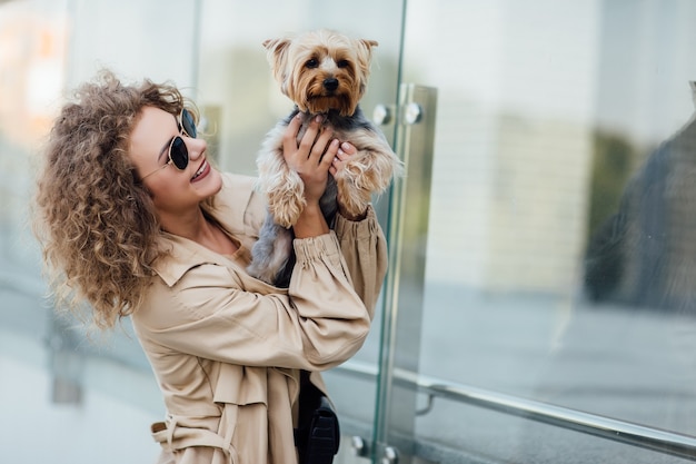 Portrait d'été d'une jeune femme en vêtements nus sur la nature avec un chien de race Chihuahua. Joli concept.