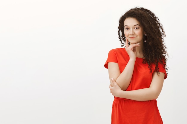 Portrait d'étudiante charmante curieuse en robe rouge à la mode