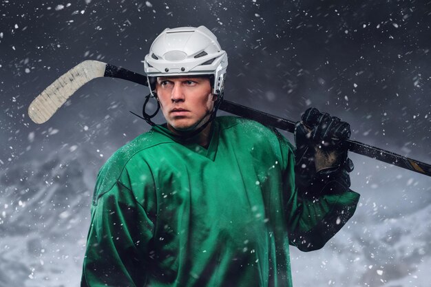 Portrait extérieur d'un joueur de hockey professionnel dans une tempête de neige.