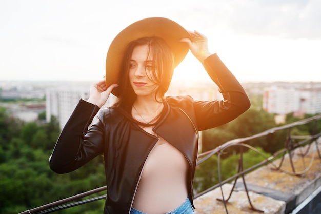 Portrait d'une fabuleuse jeune femme en vêtements décontractés posant avec un chapeau orange