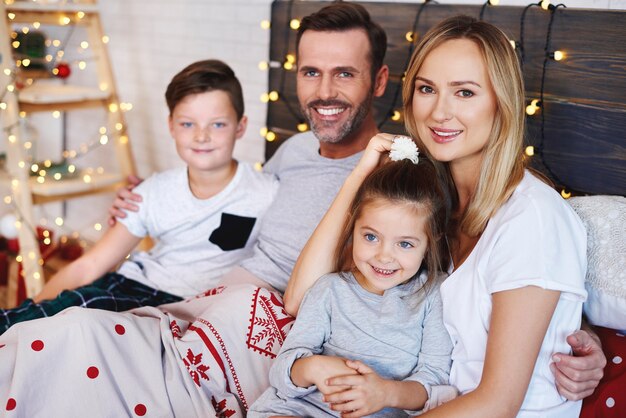 Portrait de famille au lit à Noël