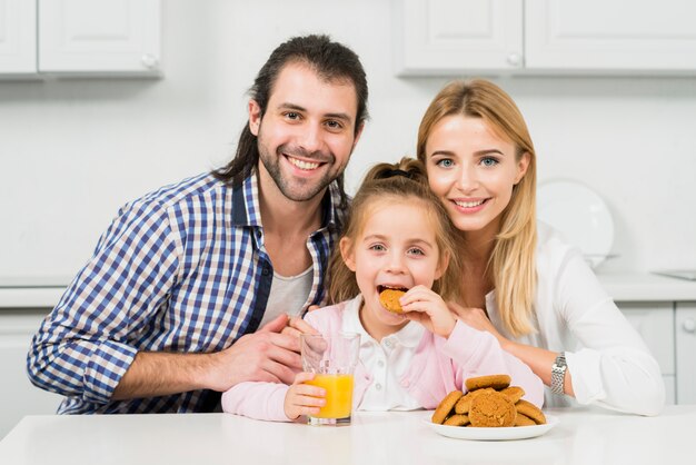Portrait de famille avec des biscuits et du jus