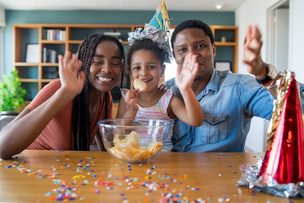Photo gratuite portrait d'une famille fêtant son anniversaire en ligne lors d'un appel vidéo tout en restant à la maison