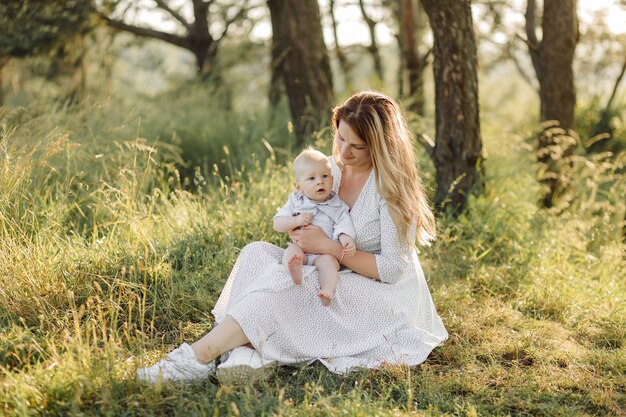 Portrait de famille heureuse au coucher du soleil, passer du temps et jouer dans la nature.