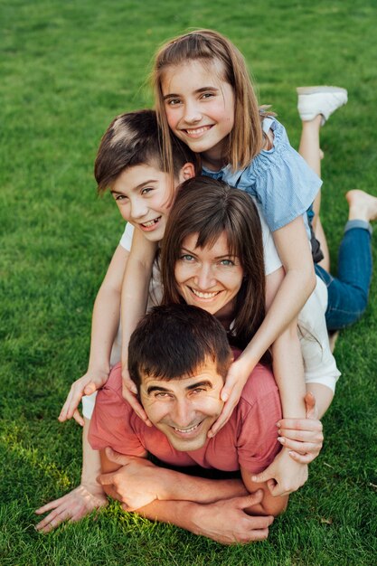 Portrait de famille heureuse, couché sur l'herbe dans le parc