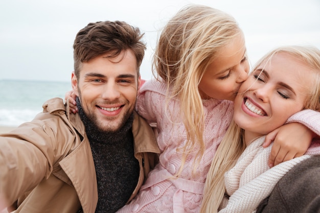 Portrait d'une famille joyeuse avec une petite fille jouant