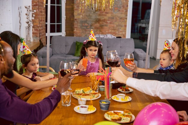 Portrait de famille multiethnique heureuse célébrant un anniversaire à la maison